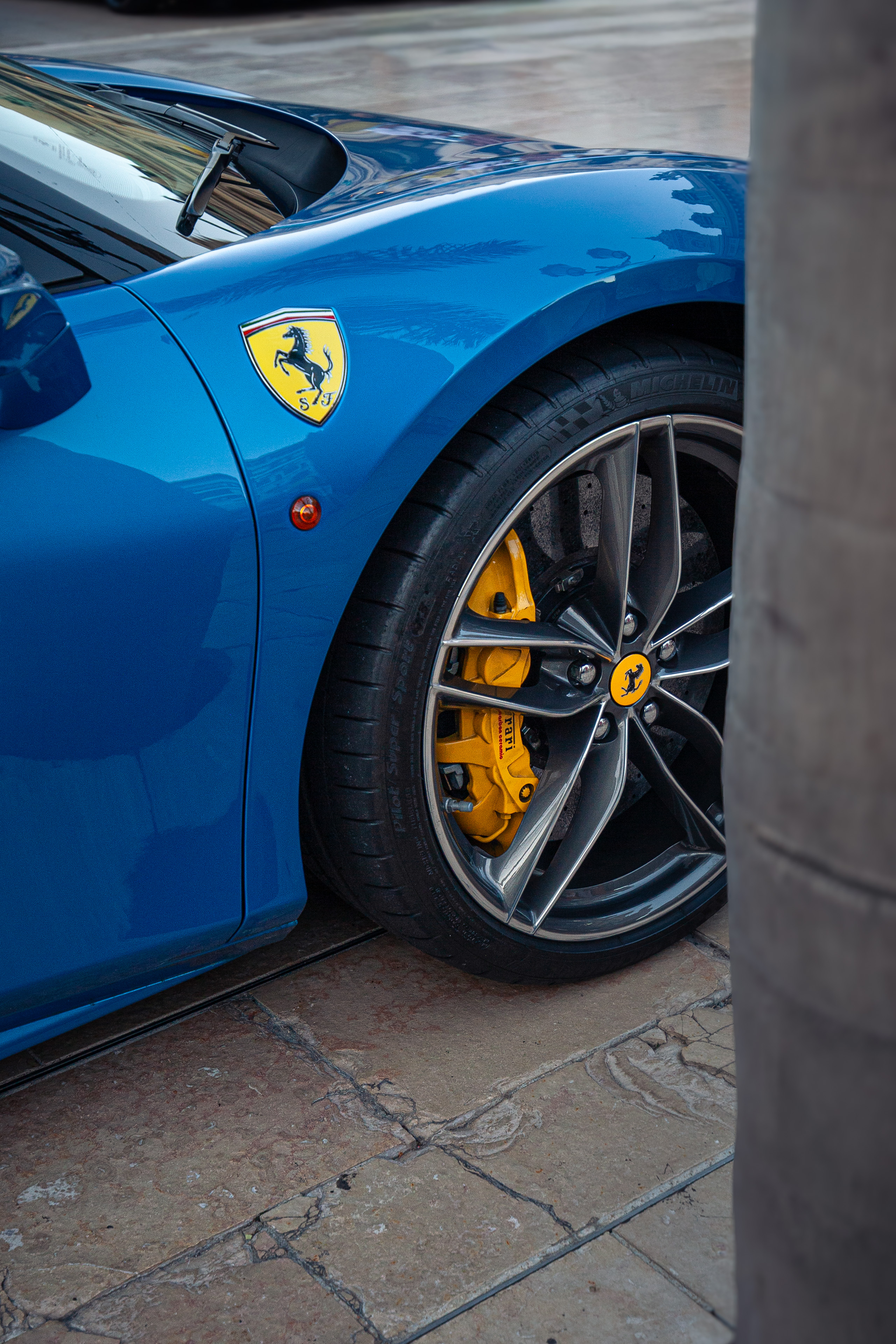 Rad-Detail eines blauen Ferrari mit gelben Bremssätteln