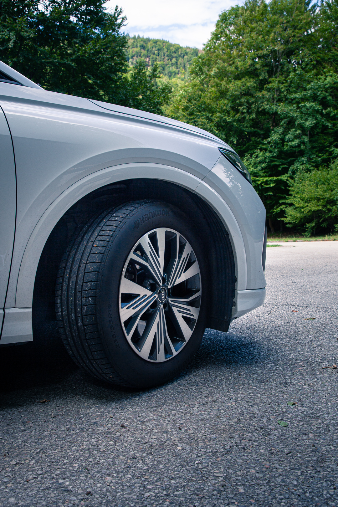 Rad-Detail eines silbernen Audi SUV vor Waldkulisse