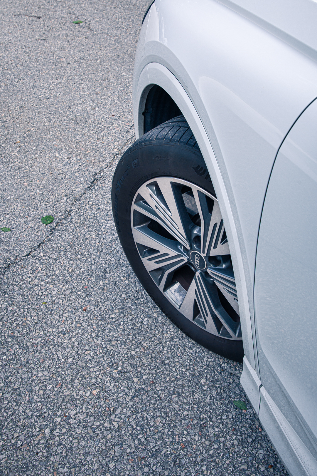 Rad-Detail eines weißen Audi auf Schotterweg