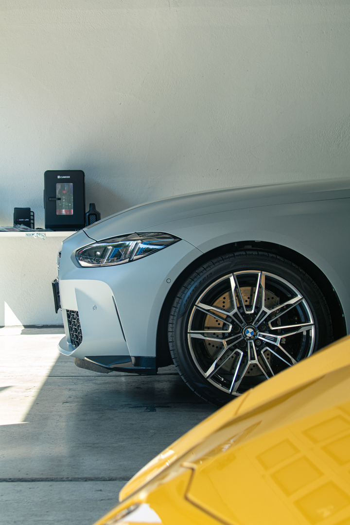 Silberner BMW, Rad- und Frontdetail in der Garage