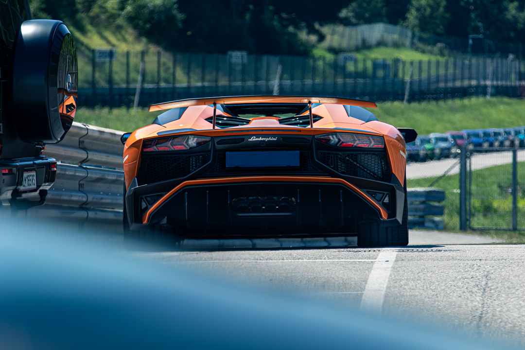 Oranger Lamborghini Aventador SV, Heckansicht auf der Rennstrecke