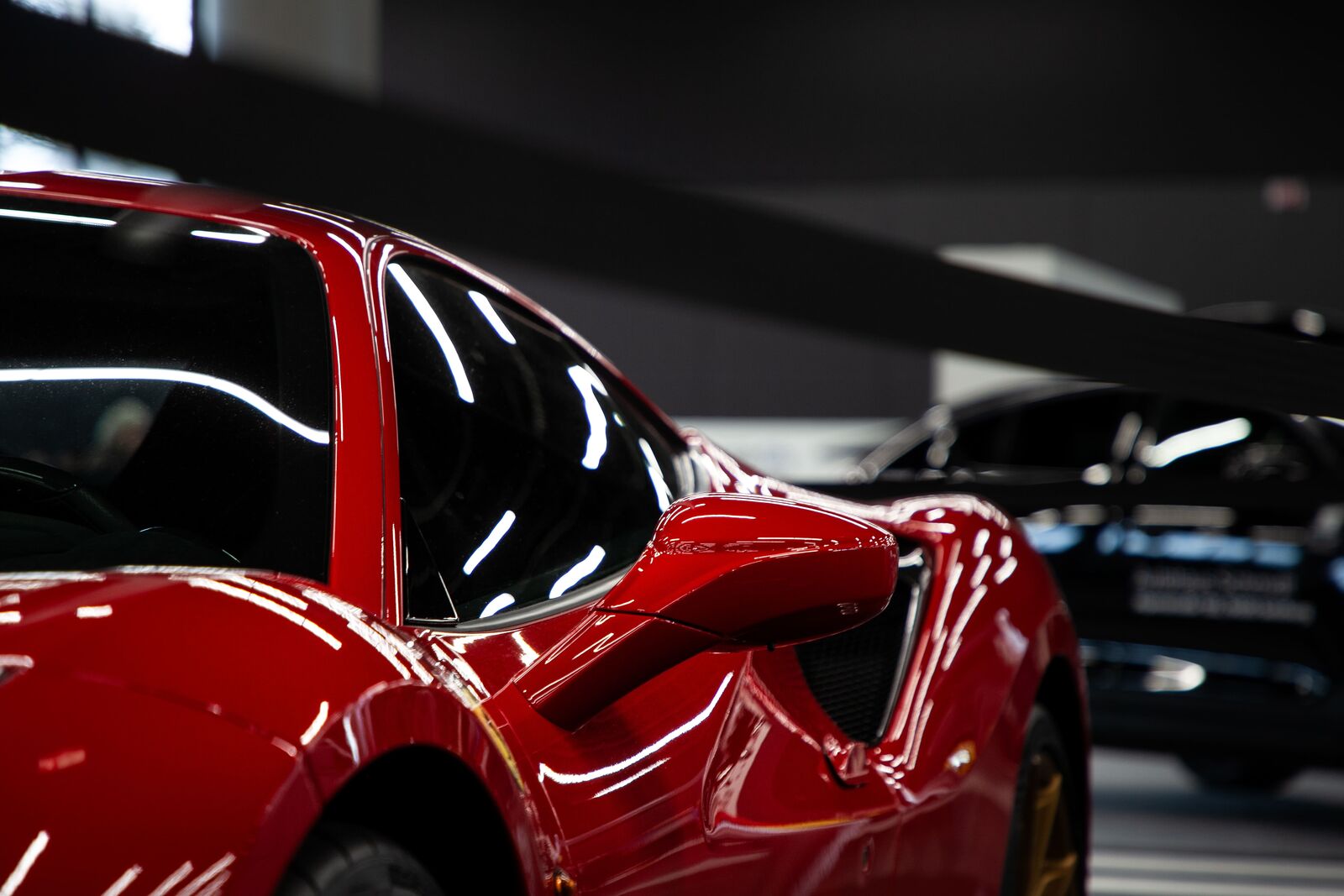 Roter Ferrari 296 GTB auf einer von Palmen gesäumten Straße