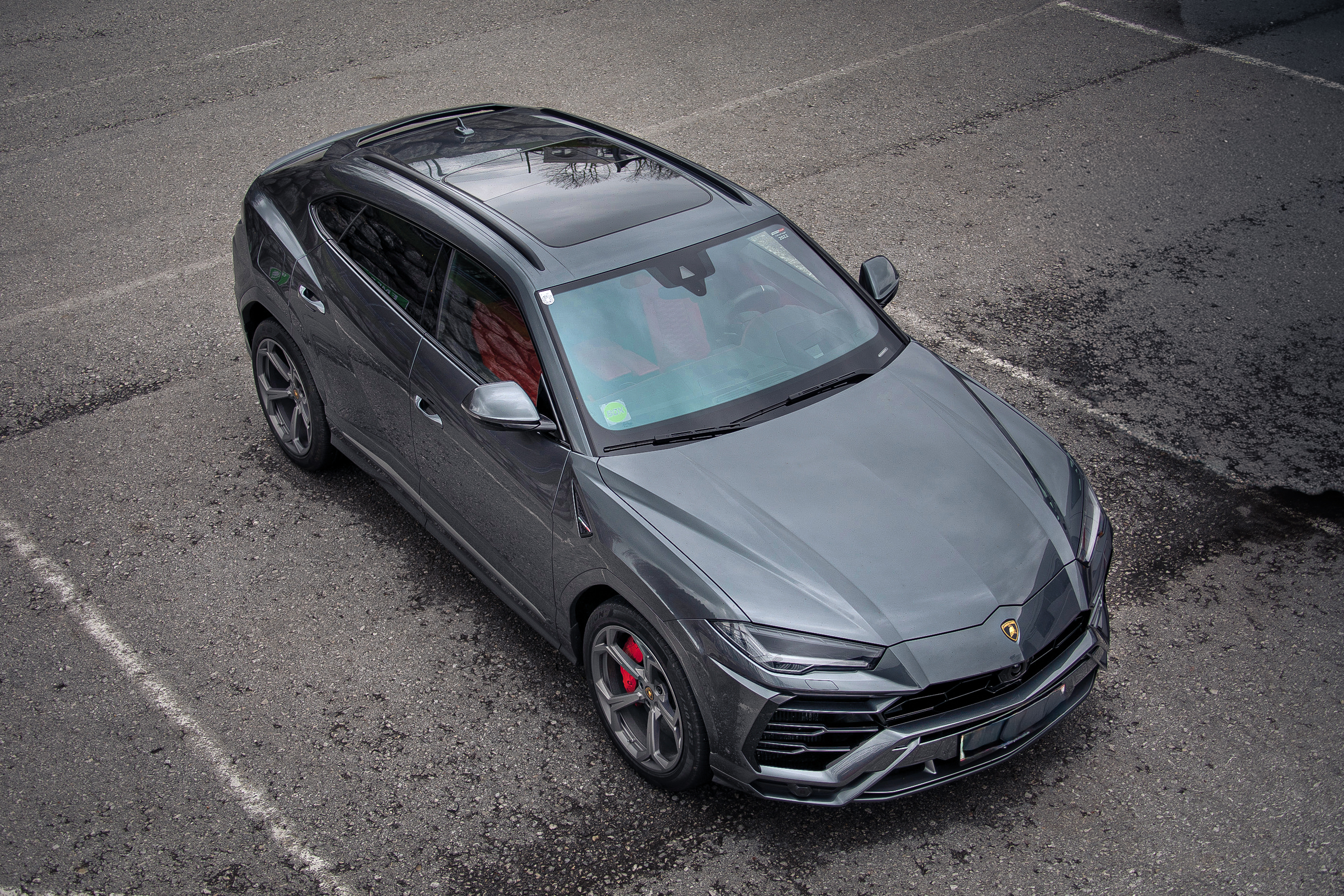 Grauer Lamborghini Urus von oben auf einem Parkplatz