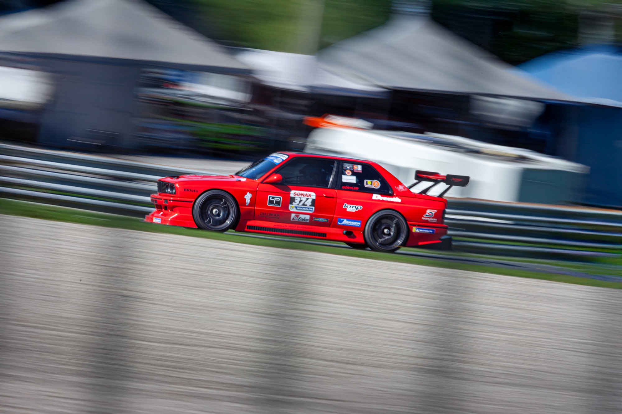 BMW E30 mit Startnummer 374 im Panning-Shot auf der Rennstrecke