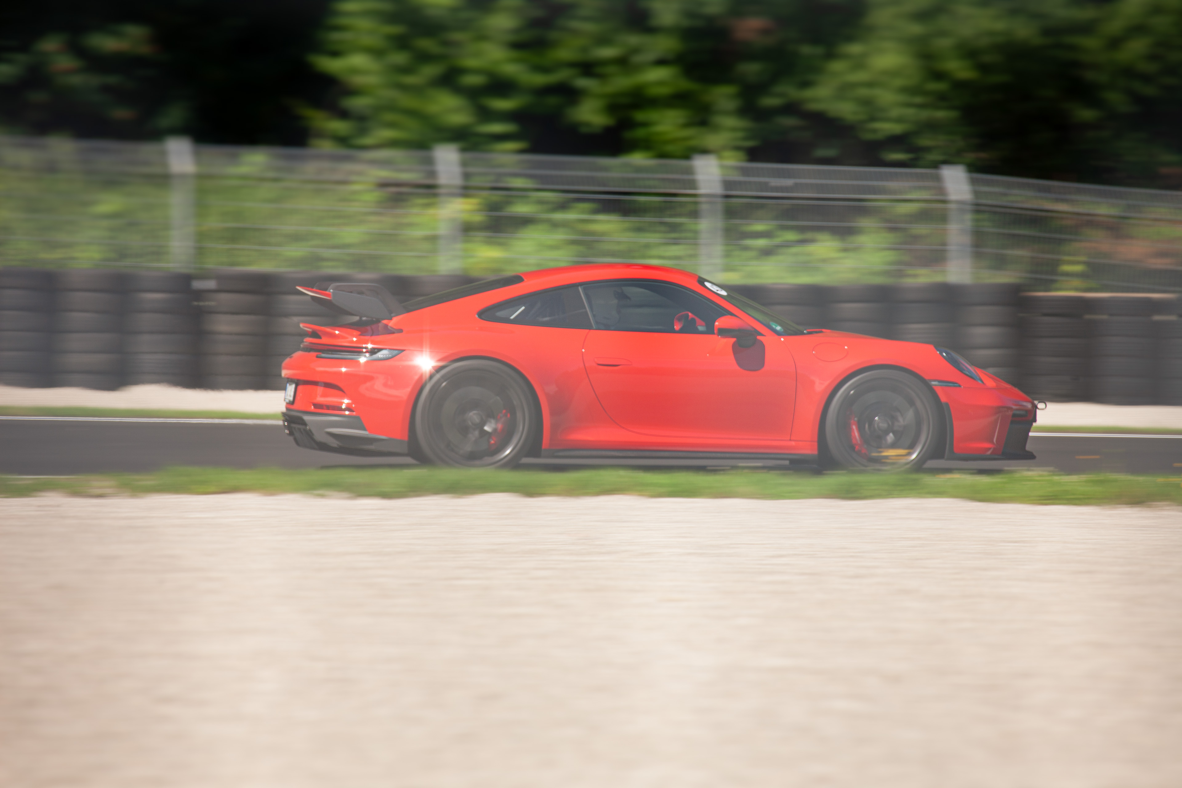 Roter Porsche 911 GT3 in voller Fahrt auf der Rennstrecke