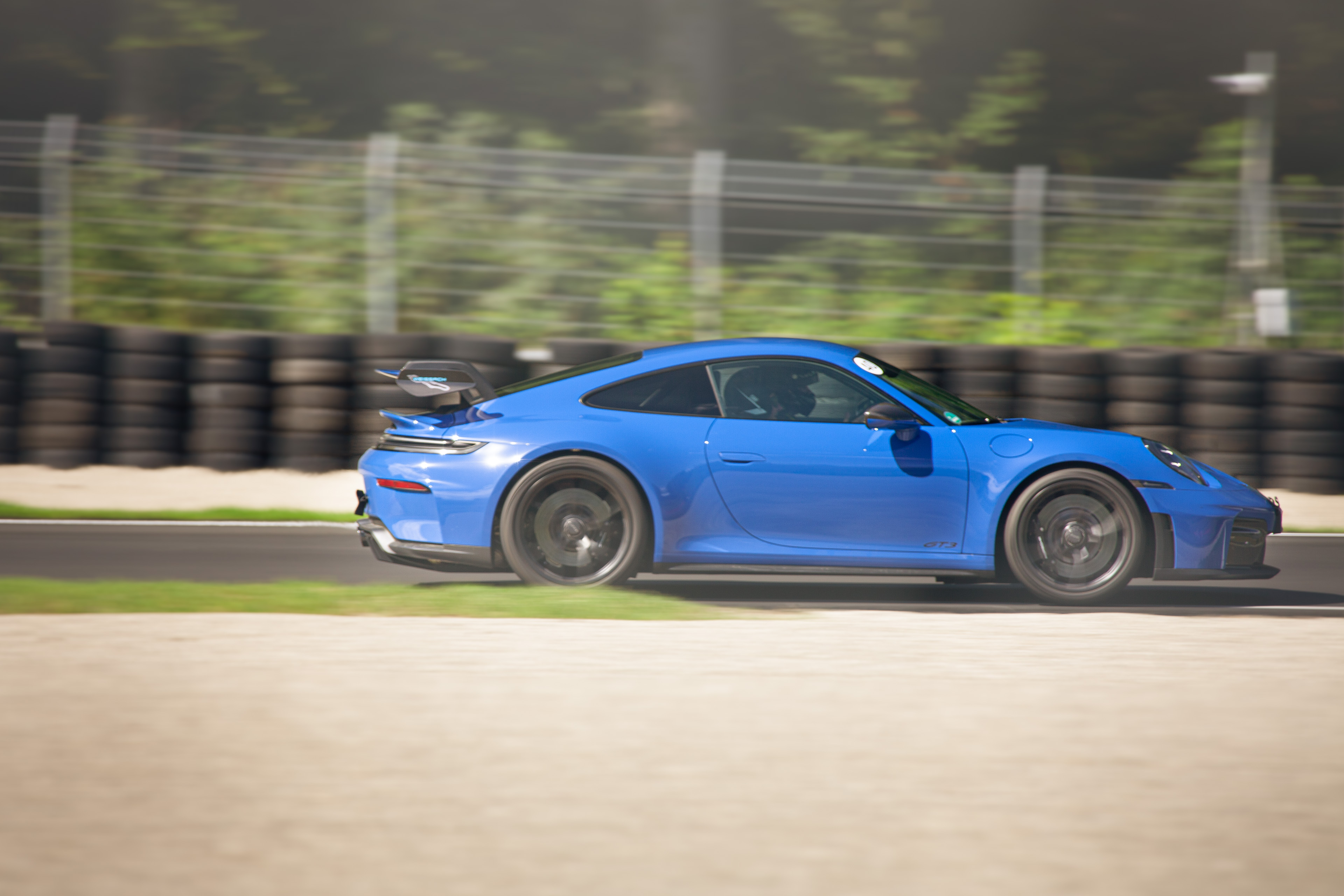 Blauer Porsche 911 GT3 in voller Fahrt auf der Rennstrecke