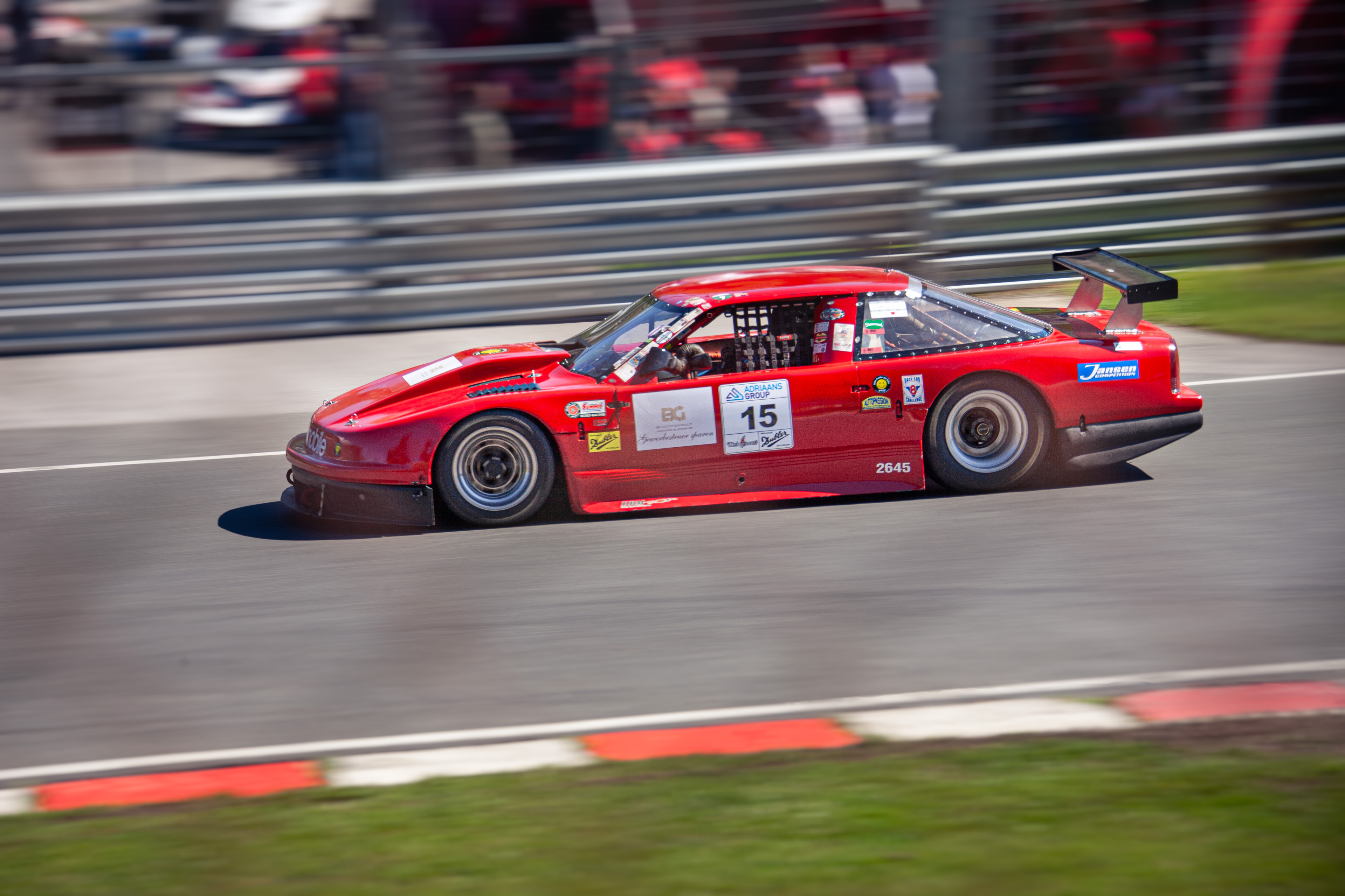 Roter Rennwagen mit Startnummer 15 auf der Rennstrecke