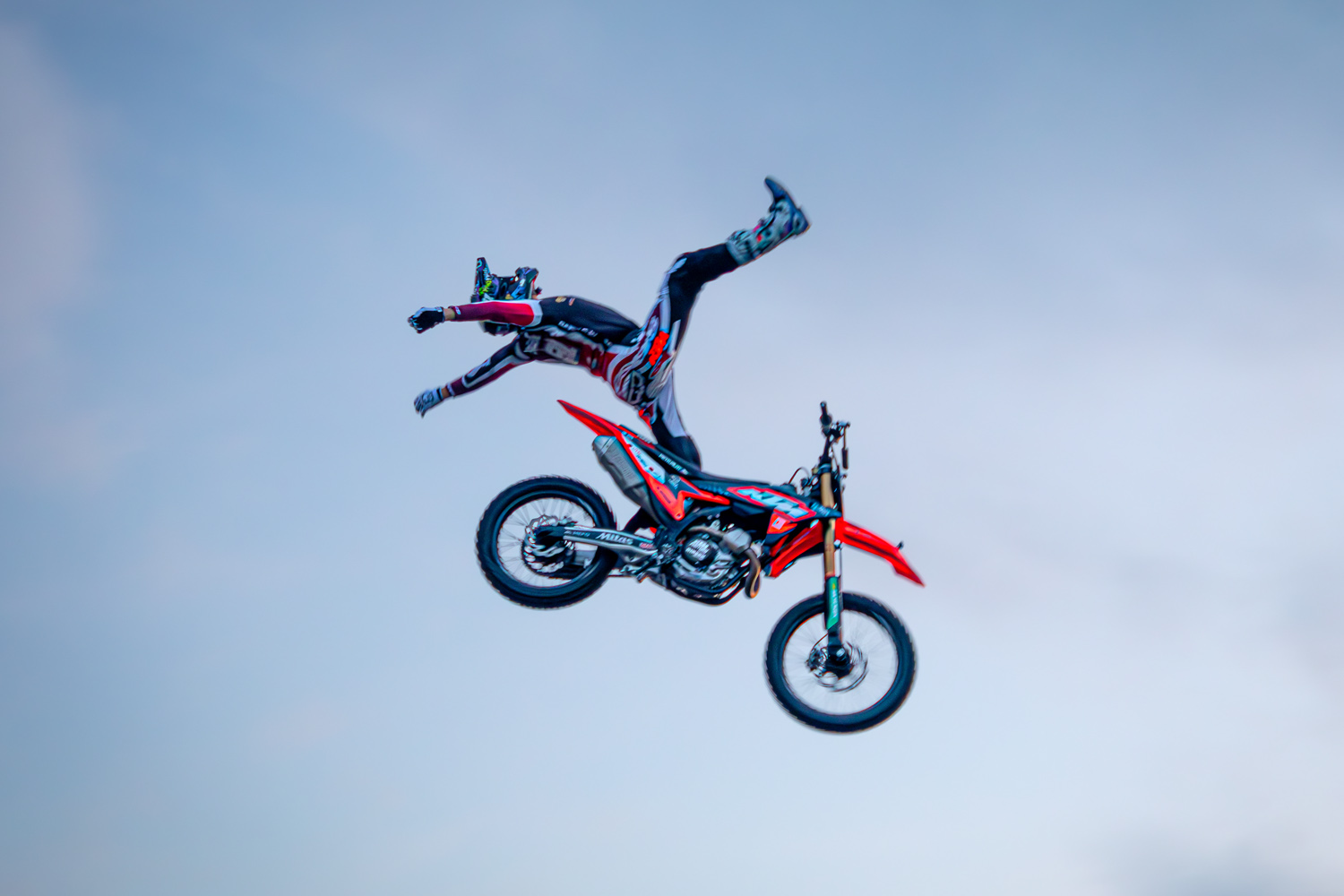 Freestyle-Motocross-Fahrer bei einem Superman-Trick in der Luft