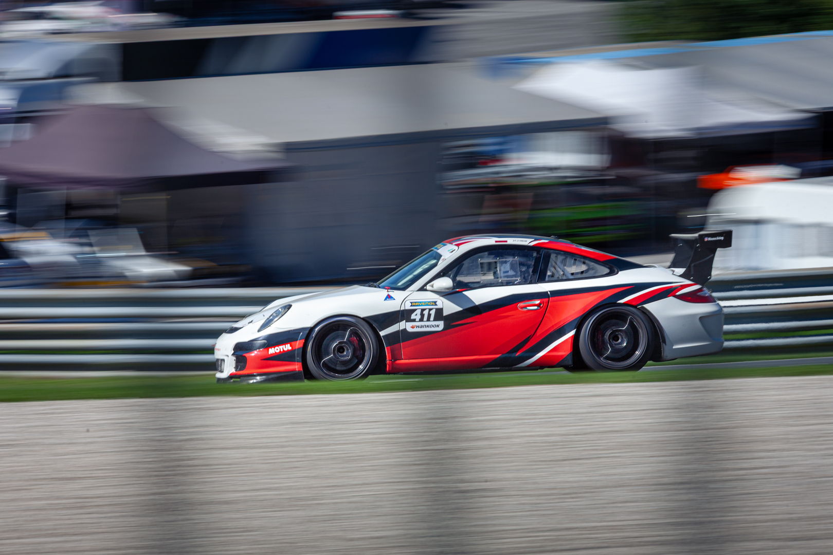 Rot-weiß-schwarzer Porsche 911 GT3 mit Startnummer 411 im Panning-Shot