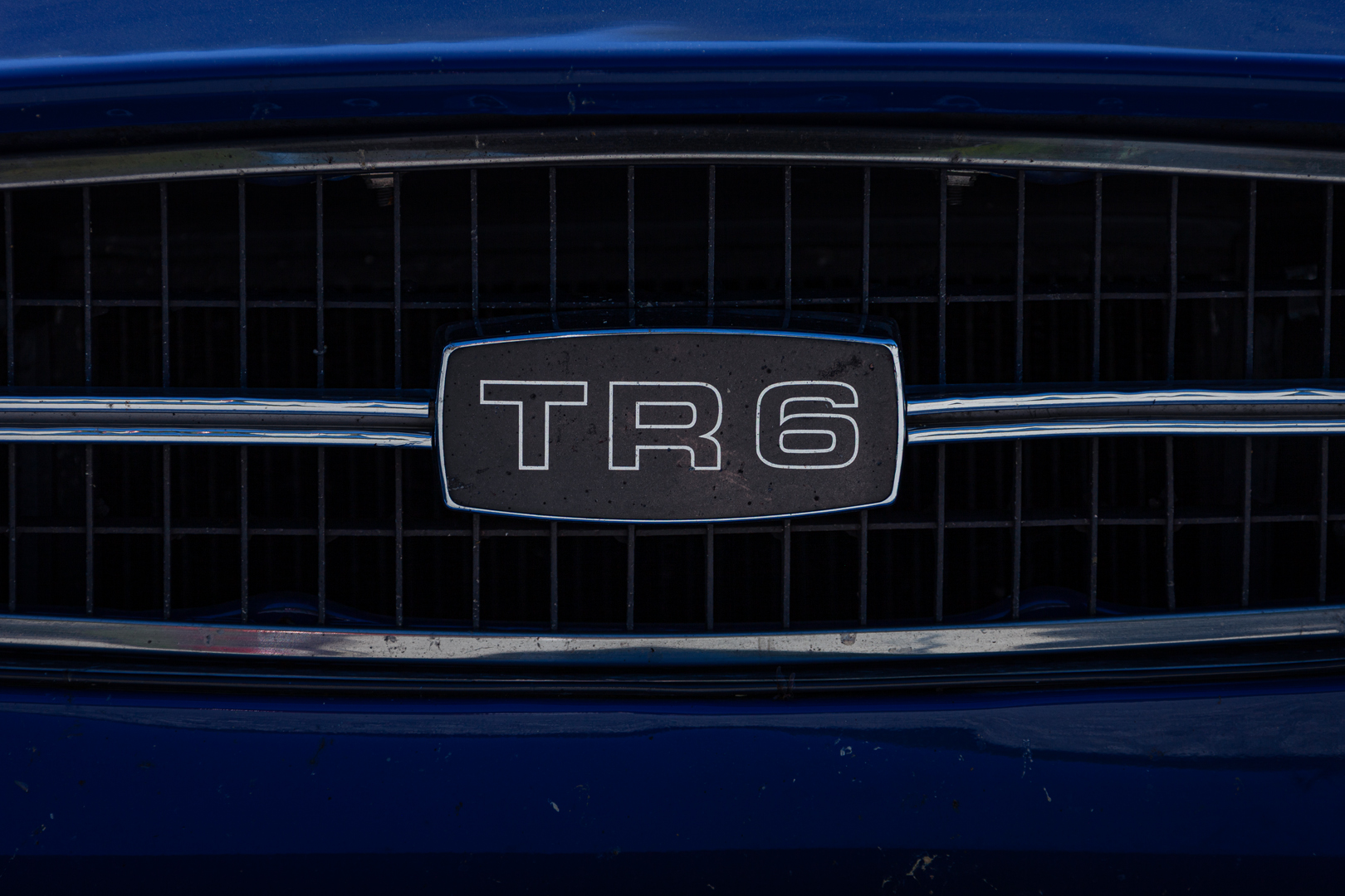 Kühlergrill-Detail eines blauen Triumph TR6 mit Emblem