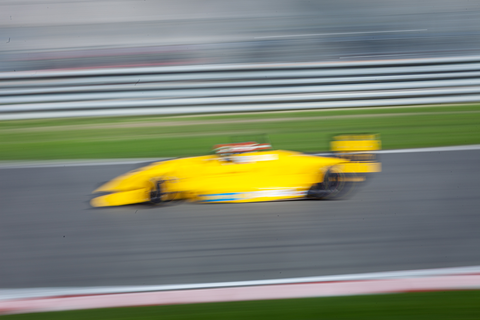 Gelber Formelrennwagen im Panning-Shot mit Bewegungsunschärfe