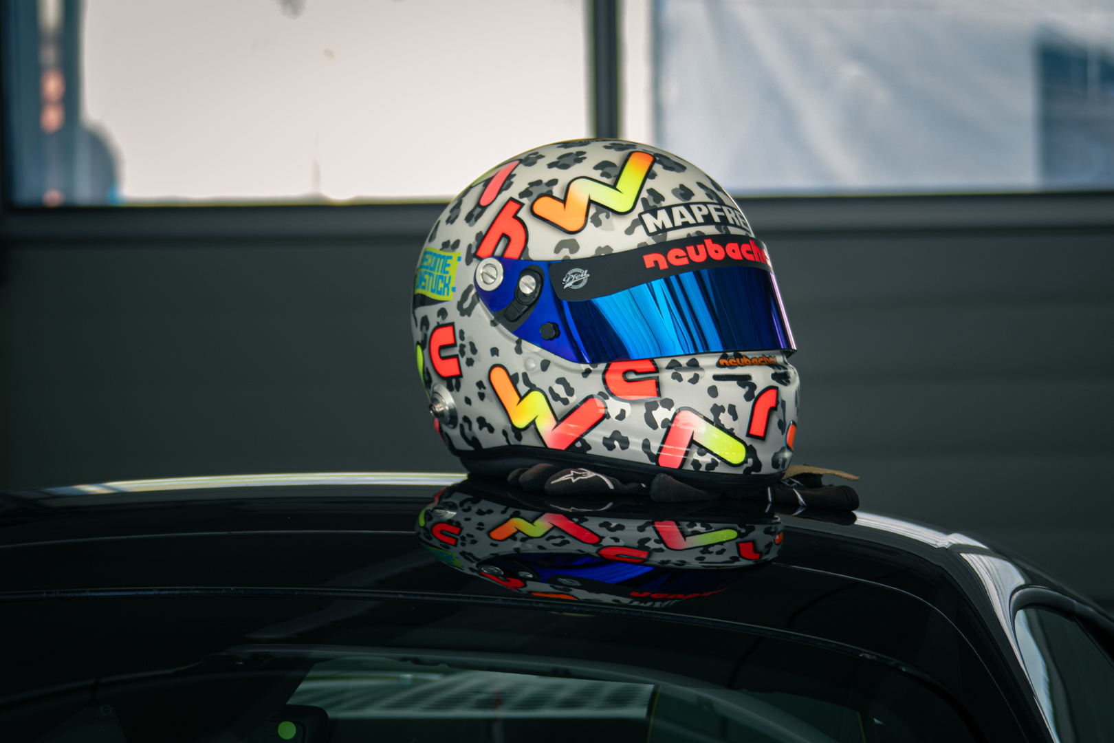Rennhelm mit auffälligem Leoparden-Design auf einem Fahrzeugdach