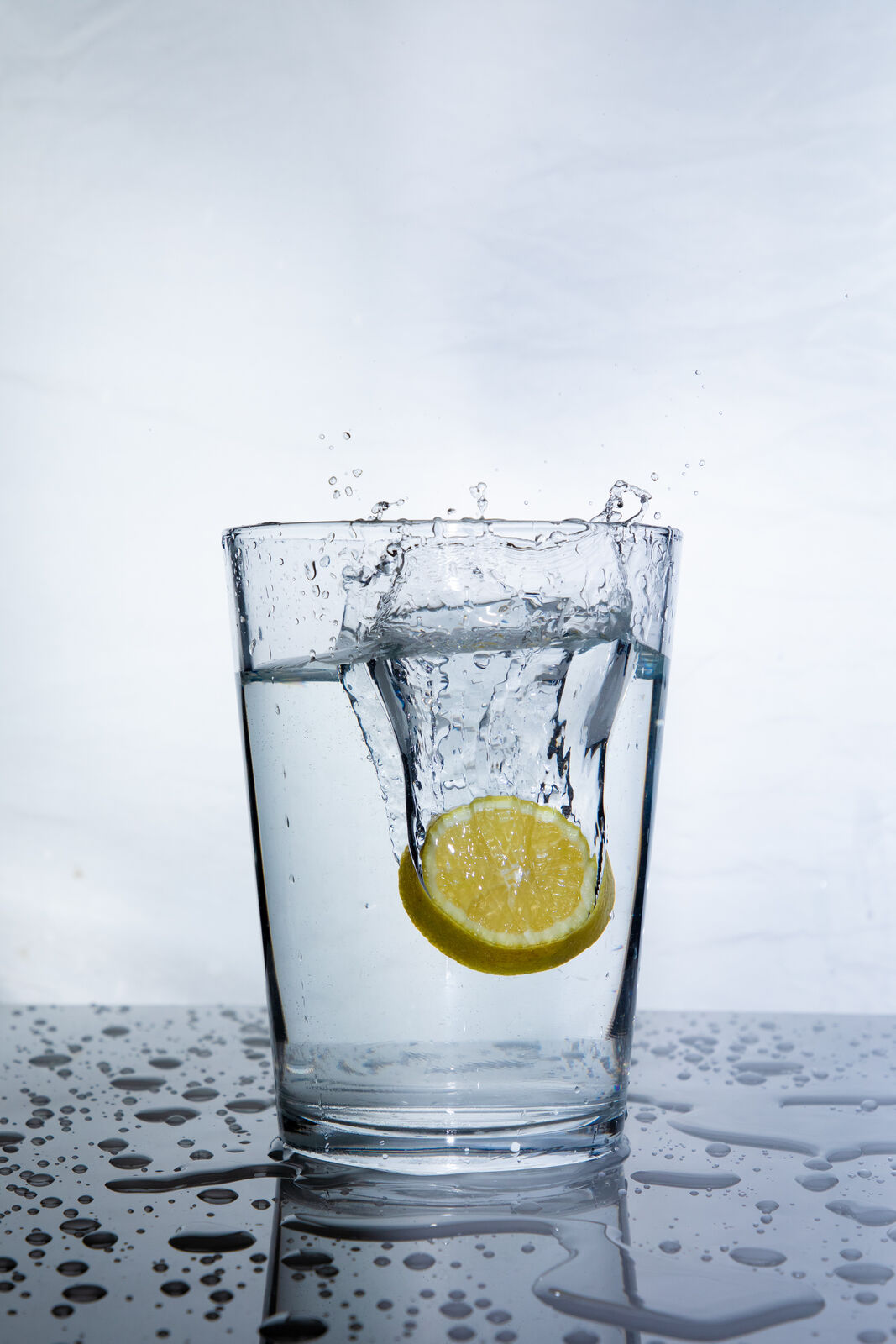 Zitronenscheibe spritzt ins Wasserglas