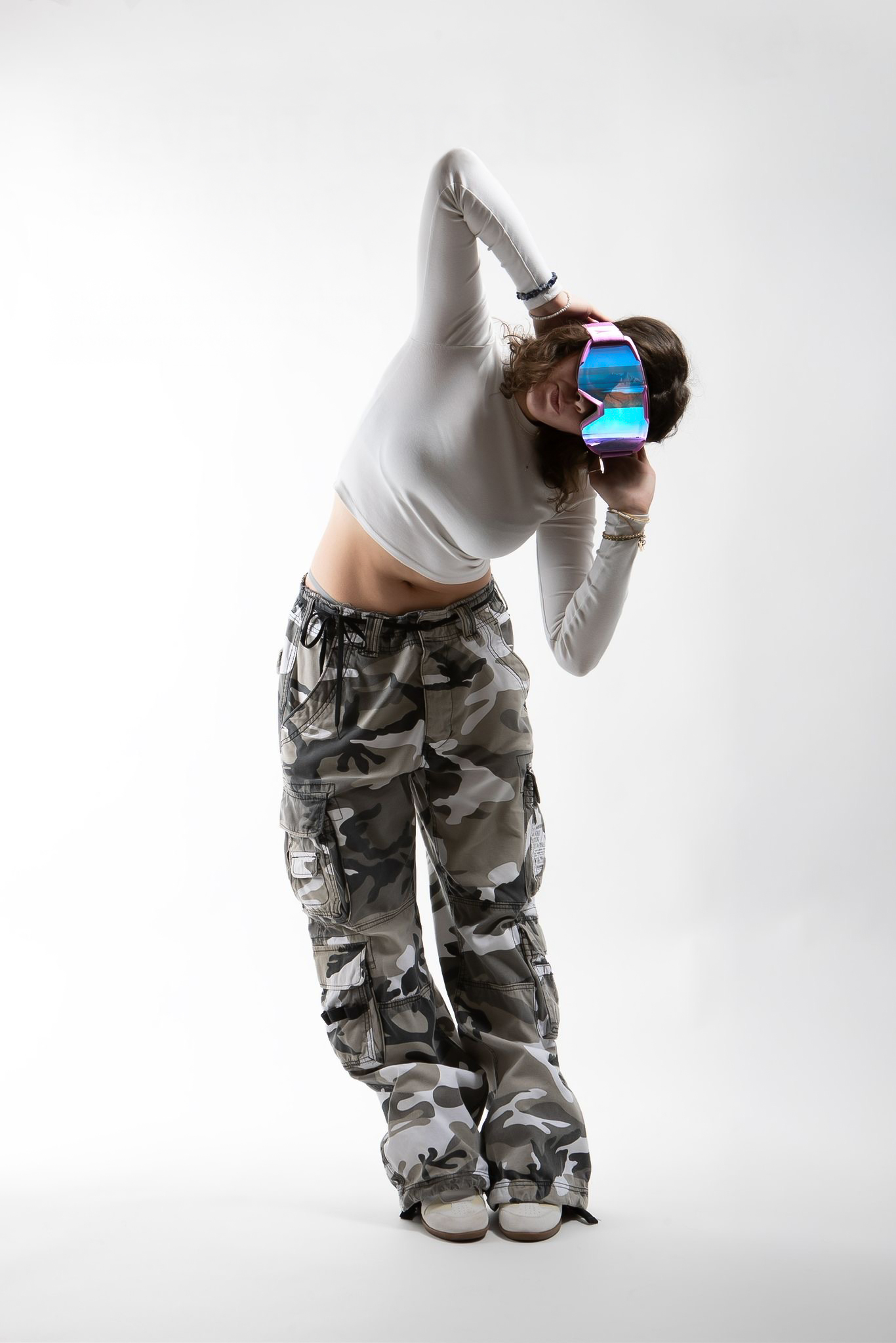 Model posiert mit Skibrille im Studio, weißer Hintergrund
