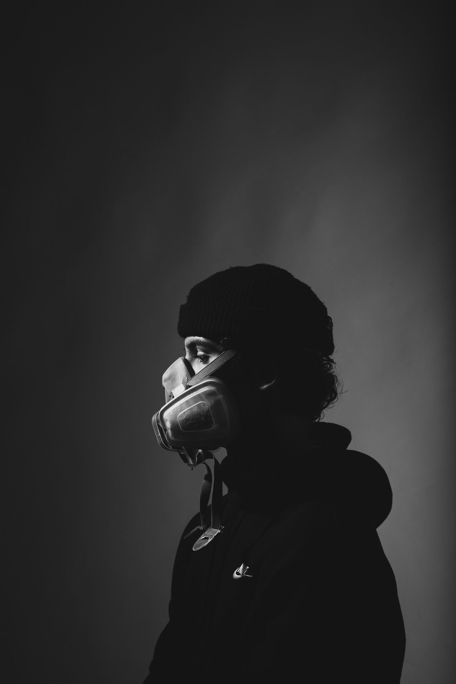 Schwarz-Weiß Studio-Porträt mit Atemschutzmaske — kreative Fotografie