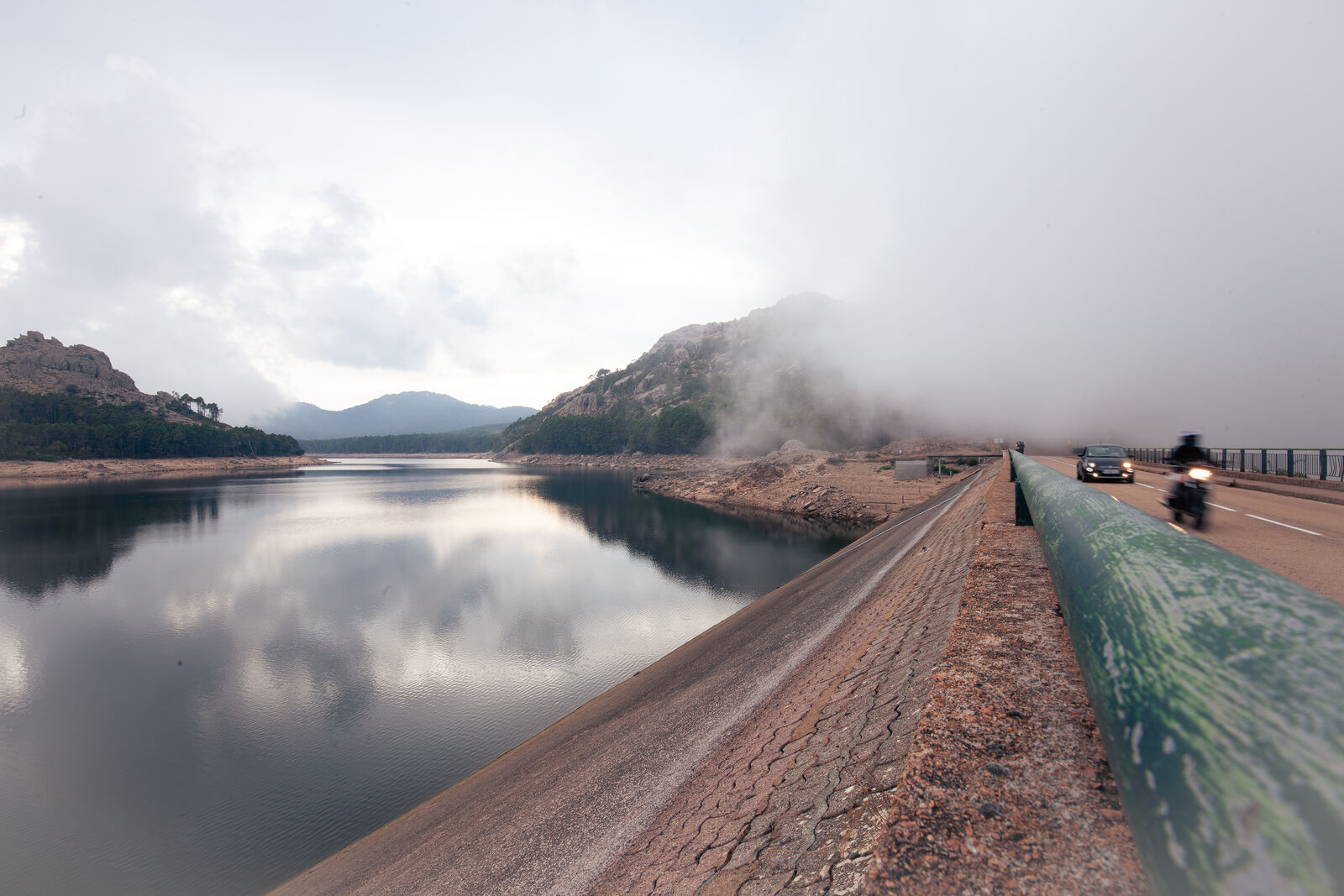 Straße am Stausee im Nebel